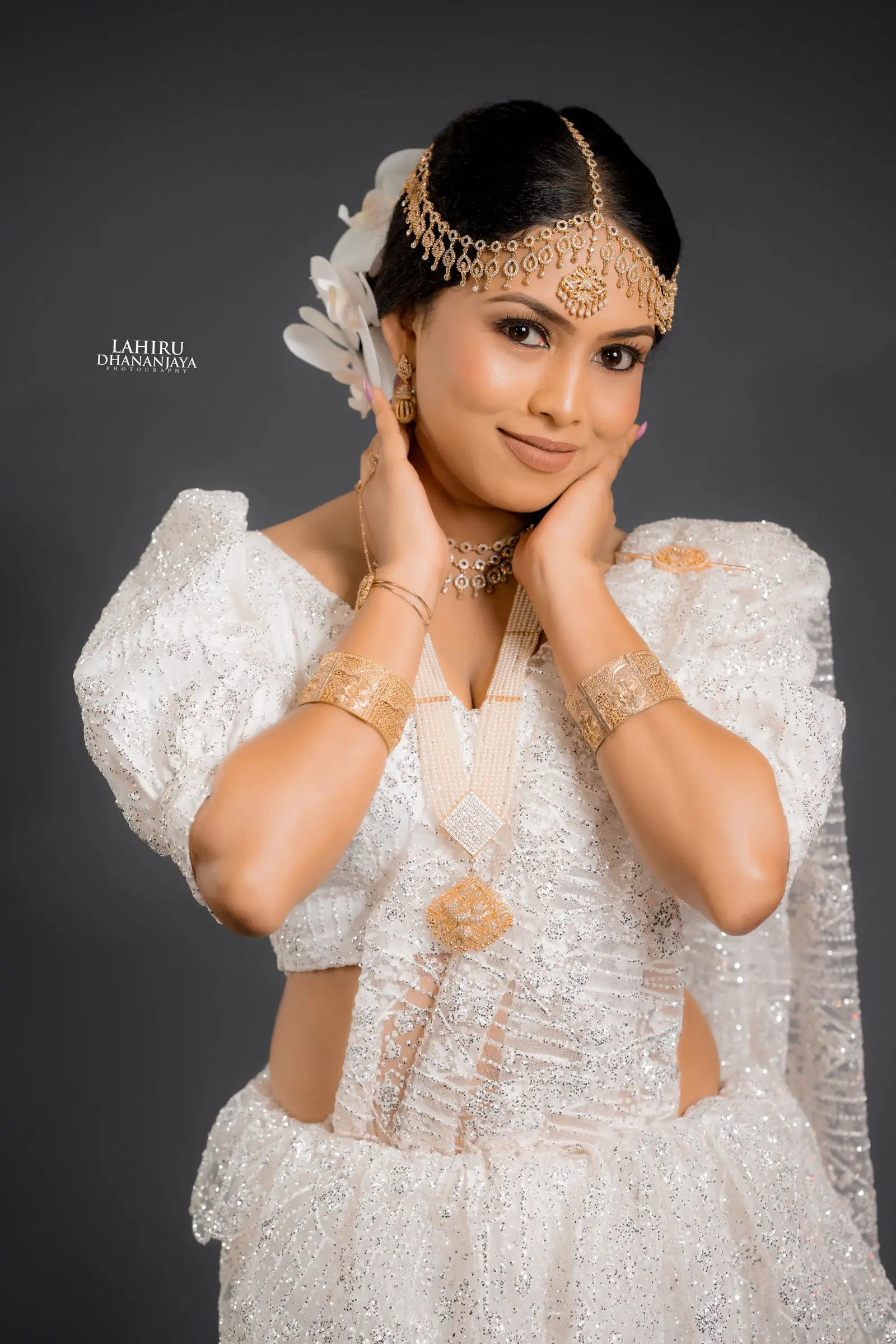 Smiling bride with her hands at her face in studio light