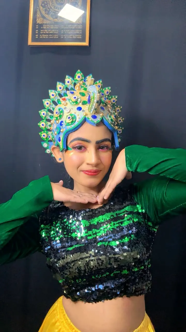 Client in a peacock-feather crown with bold colourful makeup