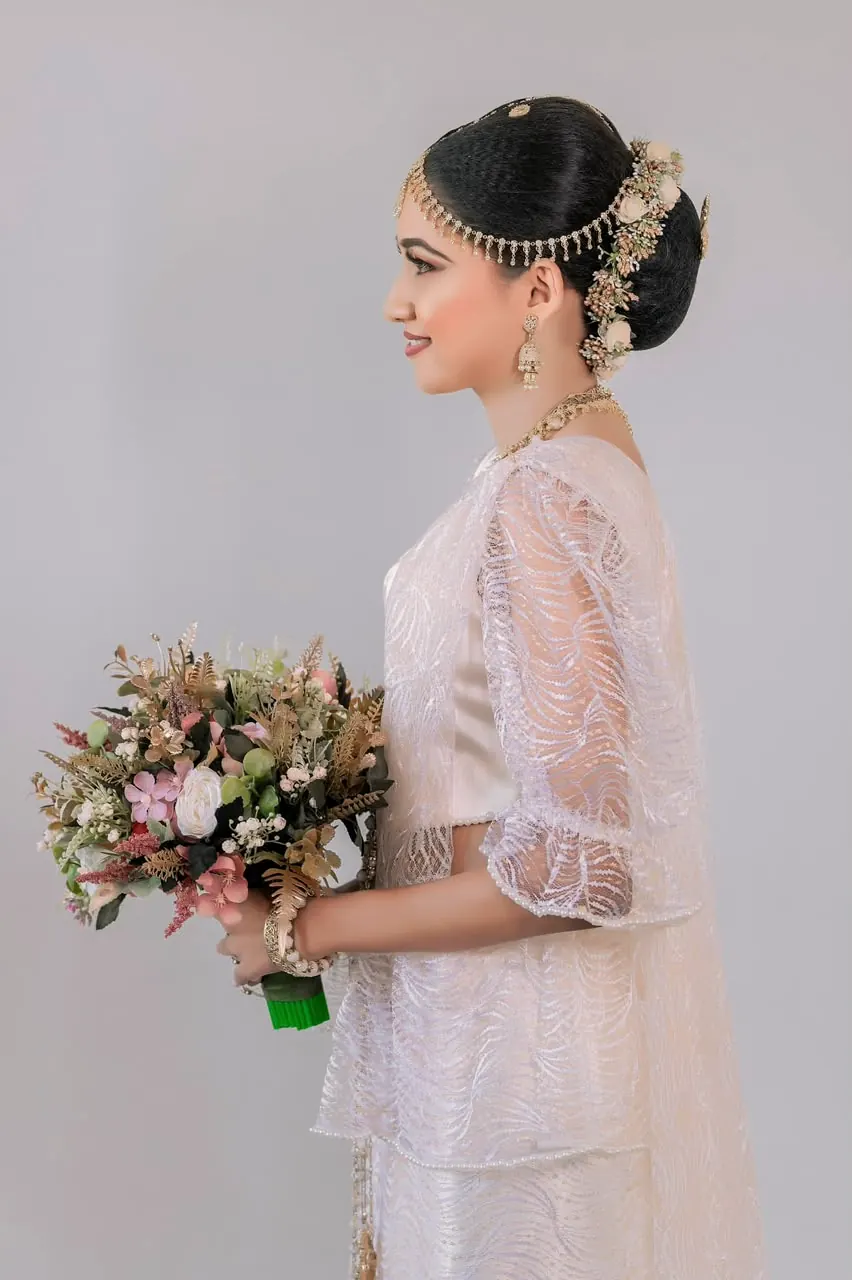 Bride in profile with a bouquet and hair pinned with flowers